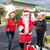 Two individuals stand with Santa 