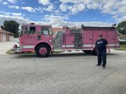 Entry 108, an individual stands in front of a pink fire engine