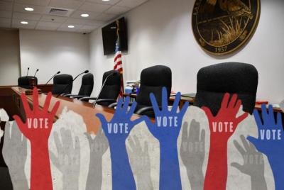 Graphic of raised hands over image of Lake Clarke Shores Council chamber