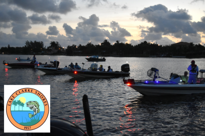 Fishing tournament participants on their boats in the lake with the fishing tournament bass logo on the bottom left of picture