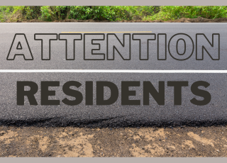 A picture of a roadway with text reading “Attention Residents.” 