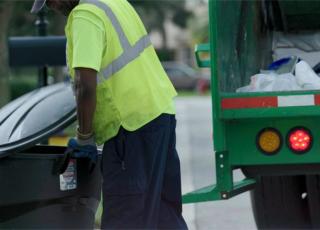 sanitation worker collecting a can